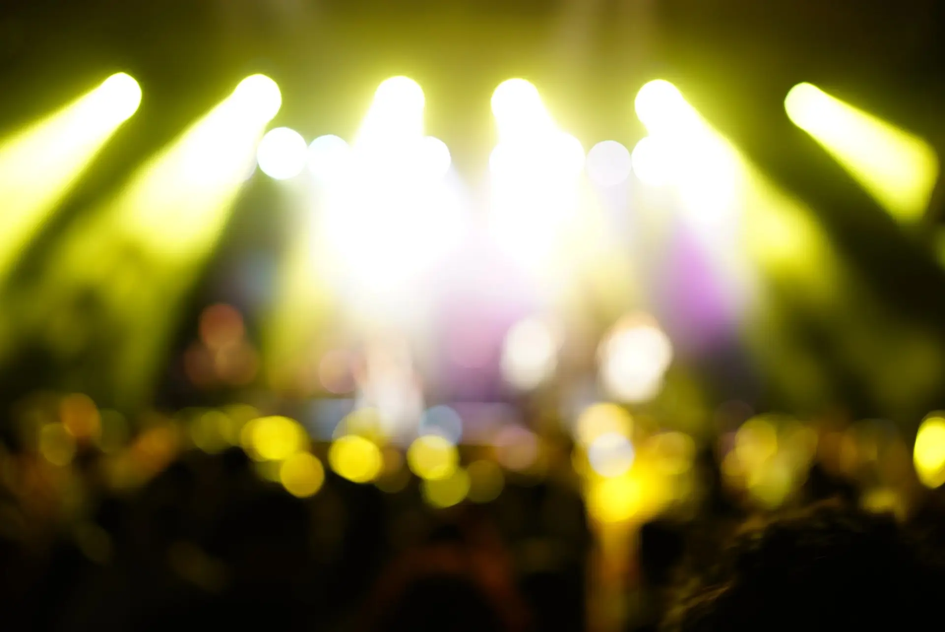Crowd facing a brightly lit pageant-style stage